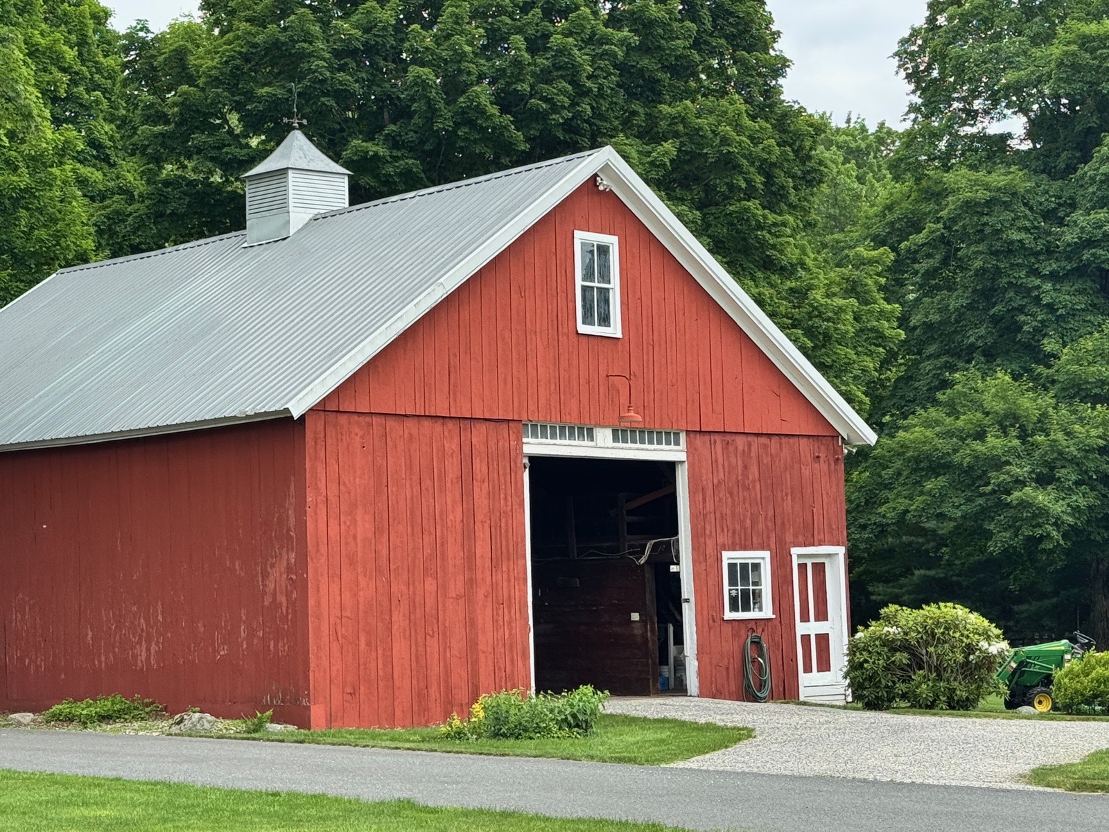 A red barn surrounded by greenery in Wilbraham Center